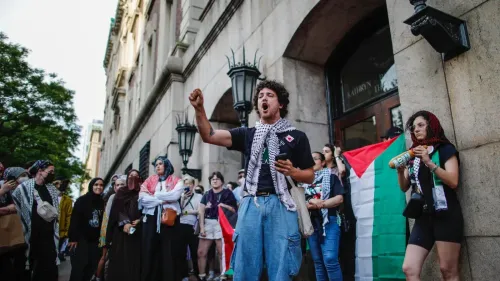 محتجون يحملون الأعلام الفلسطينية في جامعة كولومبيا، يعبرون عن دعمهم للقضية الفلسطينية وسط أجواء من التوترات الأكاديمية.