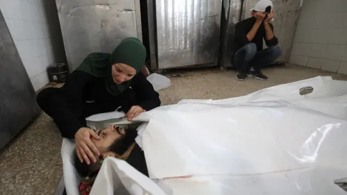 امرأة فلسطينية تودع جثمان رجل مغطى بكيس أبيض في مشهد يعكس مأساة الصحفيين الفلسطينيين الذين قُتلوا في غزة وسط جدل حول إحصائيات لجنة حماية الصحفيين.