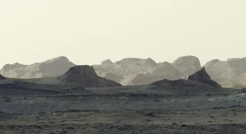 قمم زعانف الياردانغ اللامعة خلف طبقات جبل شارب الصخرية في فوهة غيل على المريخ عند شروق الشمس، ملتقطة بواسطة مركبة Curiosity.