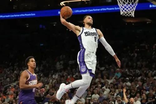 لاعب ساكرامنتو كينجز يسجل نقطة في الهواء بينما يراقبه لاعب من فينيكس صنز، خلال مباراة مثيرة في الدوري الأمريكي للمحترفين.