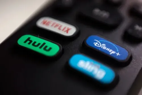 أزرار التحكم عن بُعد مع شعارات Hulu وDisney+، تشير إلى ارتفاع معدلات إلغاء الاشتراكات في خدمات البث خلال سبتمبر.