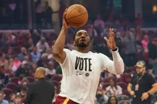 دونوفان ميتشل يسدد كرة سلة أثناء الإحماء، مرتديًا قميصًا يحمل كلمة "صوت"، استعدادًا لمباراة كليفلاند ضد أتلانتا.