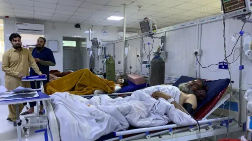 رجال يتواجدون في غرفة مستشفى حيث يرقد مرضى على أسرة طبية، مع وجود أجهزة طبية وأنابيب أكسجين، تعكس الوضع الصحي الصعب.