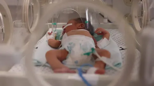 طفل فلسطيني حديث الولادة في حضانة طبية، يتلقى الرعاية بعد عودته من العلاج في الخارج، وسط ظروف إنسانية صعبة في غزة.
