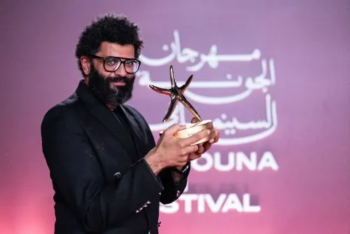 مخرج أحمد حسونة يحمل جائزة النجمة الذهبية لفيلم "Citizen Osama" الوثائقي في مهرجان الجونة السينمائي.