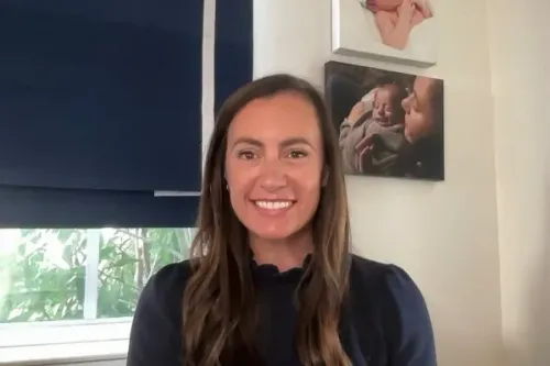 إميلي غريغوري، الممثلة الجديدة للدائرة التي تضم منتجع مار-أ-لاغو، مبتسمة في منزلها مع صور عائلية خلفها، تعكس تفاؤل الديمقراطيين في فلوريدا.