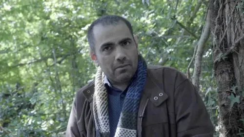 غانم المصارير، ناشط حقوقي سعودي، يظهر في غابة، مع تعبير جاد، بعد حكم المحكمة العليا بتعويضه عن الأذى النفسي الناتج عن اختراق هاتفه.