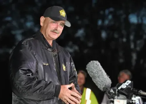 مأمور سابق في ساوث كارولينا يتحدث للصحافة، حيث يواجه تهمًا بالسرقة والاحتيال، وسط خلفية غامضة.