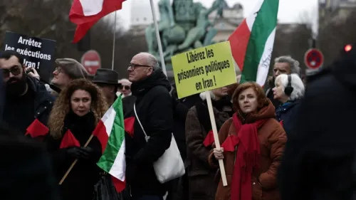 محتجون يحملون لافتات تطالب بالإفراج عن السجناء السياسيين في إيران، مع أعلام تمثل الهوية الإيرانية، في تظاهرة في مدينة أوروبية.