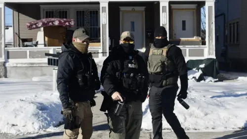 رجال شرطة يرتدون زي إنفاذ قوانين الهجرة والجمارك في مينيسوتا، وسط الثلوج، أثناء تنفيذهم عمليات اعتقال للاجئين.
