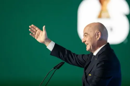 إنفانتينو، رئيس FIFA، يعلن ترشحه لولاية ثالثة خلال مؤتمر صحفي في المغرب، مع خلفية شعار البطولة.