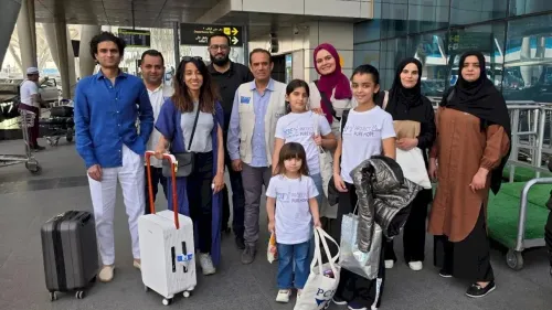 طفلتان فلسطينيتان، راما وغنى، مع فريق الدعم في مطار بعد وصولهن إلى المملكة المتحدة لتلقي العلاج الطبي المتخصص.