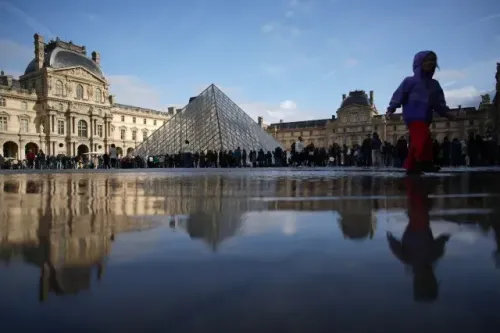 ميدان متحف اللوفر يعكس صورة الهرم الزجاجي الشهير، مع طوابير الزوار في الخلفية، مما يعكس أهمية المعلم الثقافي في باريس.