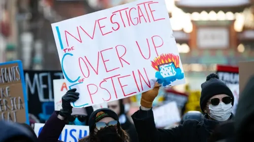 لافتة في مظاهرة تطالب بالتحقيق في قضية إبشتاين، مكتوب عليها "تحقيق في التستر على إبشتاين"، مع متظاهرين يرتدون أقنعة.