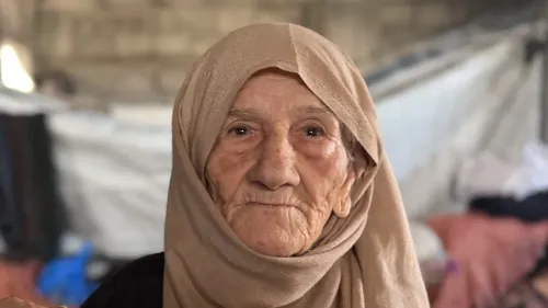 وجه امرأة مسنّة ترتدي حجابًا، تعبر عن معاناتها في غزة بعد فقدان عائلتها وبيتها، وسط ظروف قاسية من النزوح والتهجير.