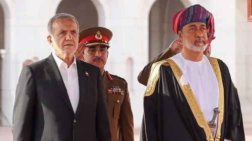 رجلان يرتديان الزي التقليدي العماني، يقفان في مناسبة رسمية، مع خلفية معمارية تعكس التراث العماني، مما يعكس العلاقات الدبلوماسية بين عمان والدول المجاورة.