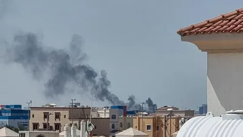 دخان أسود يتصاعد من منطقة حضرية، مع وجود مبانٍ سكنية في المقدمة، مما يعكس التوترات المستمرة في العاصمة الإثيوبية أديس أبابا.