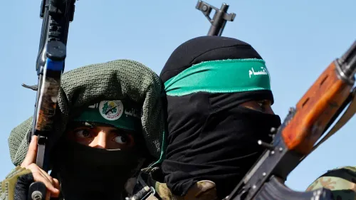 مسلحون من حركة حماس يرتدون أغطية رأس خضراء ويحملون أسلحة، في سياق اتفاق وقف إطلاق النار وتنفيذ خطة السلام في غزة.