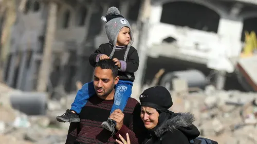 أسرة فلسطينية تمر عبر أنقاض منزل مدمَّر في خان يونس، تعبير عن الألم والأمل في العودة وسط آثار الحرب المدمِّرة.