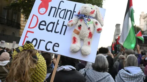 لافتة في مظاهرة تحمل دمية أرنب ملطخة بالدماء وكلمات "قوة الموت للأطفال"، تعبيرًا عن الاحتجاج ضد العنف الموجه نحو الأطفال الفلسطينيين.