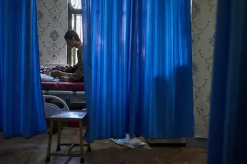 شاب يجلس بجانب سرير مريض في مستشفى بكاتماندو، حيث يُظهر التأثيرات الجسدية للاحتجاجات ضد الفساد في نيبال.