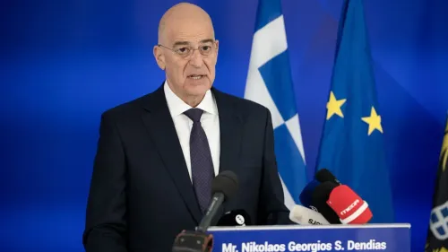 وزير الدفاع اليوناني نيكوس دندياس يتحدث في مؤتمر صحفي، مع وجود أعلام اليونان والاتحاد الأوروبي خلفه، مع التركيز على توتر العلاقات مع تركيا.