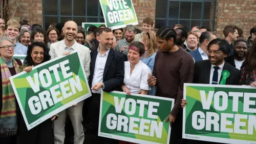 مجموعة من نشطاء حزب الخضر في لندن يحملون لافتات تدعو للتصويت للحزب، مع تعبيرات حماسية وأجواء احتفالية تعكس دعمهم للانتخابات المحلية.