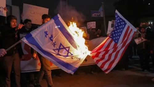 متظاهرون يحرقون علمي الولايات المتحدة وإسرائيل خلال احتجاجات ضد الحكومة، مع لافتات تعبر عن الغضب من السياسات الخارجية.