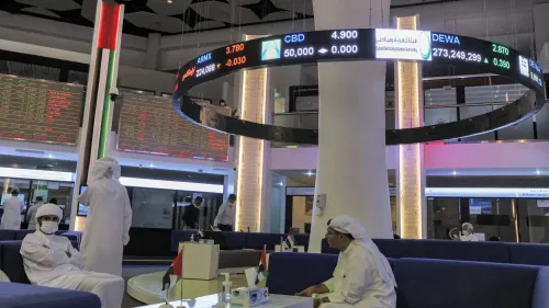 تظهر الصورة داخل سوق مالي في الإمارات، مع شاشات تعرض أسعار الأسهم. الأجواء تعكس التوتر الاقتصادي في المنطقة وسط تصاعد التوترات الإسرائيلية الإيرانية.