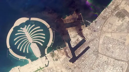 صورة جوية لجزيرة النخلة في دبي، تُظهر آثار الدخان في المياه المحيطة، مما يشير إلى الهجمات الإيرانية على البنية التحتية في المنطقة.