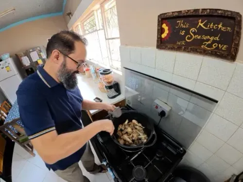 رجل يقوم بطهي الدجاج في مطبخ زيمبابوي، مع لافتة مكتوب عليها "هذه المطبخ متبل بالحب"، في إطار مسابقة طبخ دبلوماسيين.