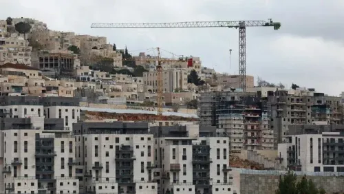 مباني جديدة قيد الإنشاء في مستوطنة إسرائيلية، مع وجود رافعة بناء في الخلفية، تعكس النشاط الاستيطاني في الأراضي الفلسطينية المحتلة.