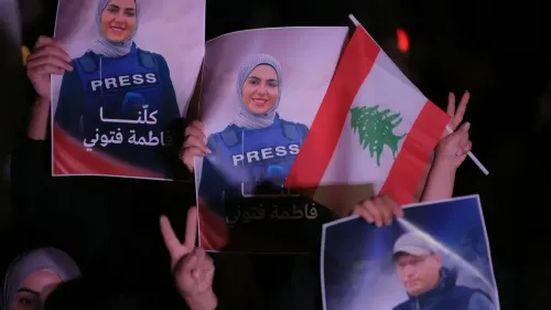 تجمع حشود من الناس في لبنان يحملون لافتات تحمل صورة الصحفية فاطمة فتوني، تعبيرًا عن التضامن والاحتجاج ضد الاعتداءات على الصحفيين.