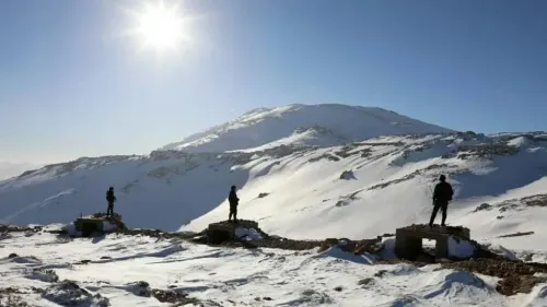 جنود إسرائيليون يقفون على مرتفعات الجولان المغطاة بالثلوج، مع جبل الشيخ في الخلفية، في سياق التوترات الإقليمية المستمرة.