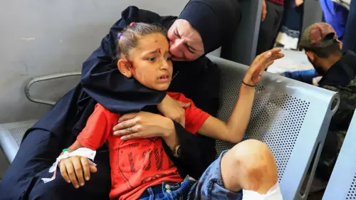 امرأة تحتضن طفلًا مصابًا في مستشفى، حيث تظهر علامات الألم والقلق على وجههما، في ظل الظروف الصعبة في غزة.