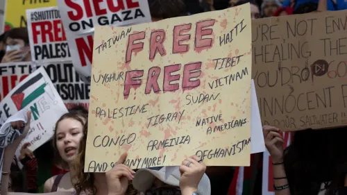 لافتة في مظاهرة تطالب بالحرية لفلسطين ودول أخرى، مع كلمات "حرية" مكتوبة بشكل بارز، تعكس التضامن مع القضايا الإنسانية.