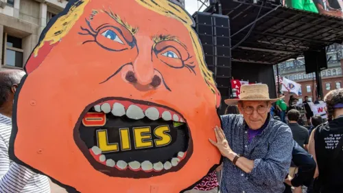 لافتة ضخمة تحمل وجه ترامب مع كلمة "أكاذيب" داخل فمه، تظهر في تجمع احتجاجي، تعكس الانتقادات لأسلوبه في الحكم.