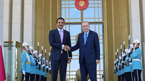 لقاء بين أمير قطر تميم بن حمد آل ثاني والرئيس التركي رجب طيب أردوغان، مع حرس الشرف في الخلفية، يعكس التعاون الإقليمي في إعادة إعمار سوريا.