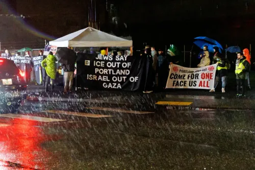 تجمع حشود في بورتلاند تحت المطر، حاملة لافتات تعبر عن معارضتها لسياسات الهجرة الإسرائيلية والأمريكية، في سياق قمع حقوق الفلسطينيين.