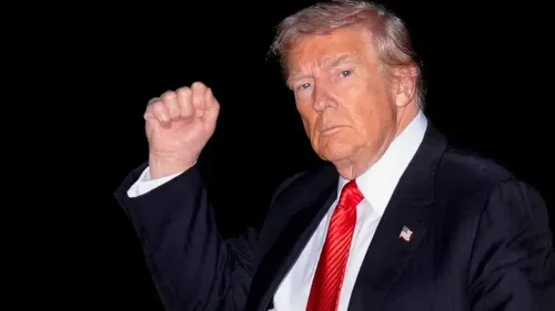 ترامب يرفع يده بإشارة قوية، مرتديًا بدلة رسمية مع ربطة عنق حمراء، في خلفية داكنة، أثناء حديثه عن السياسة الخارجية.