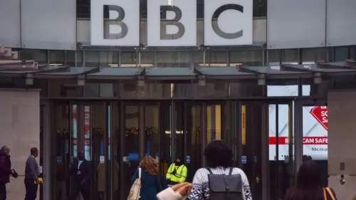 مدخل مبنى بي بي سي، حيث يظهر عدد من الأشخاص يتجهون نحو المدخل، مع لافتة واضحة تحمل شعار المؤسسة الإعلامية.