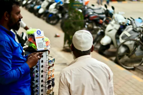 بائع هندي يعرض رمز QR للدفع عبر تطبيق PhonePe على رصيف مزدحم بالدراجات، يعكس انتشار المدفوعات الرقمية في الهند.