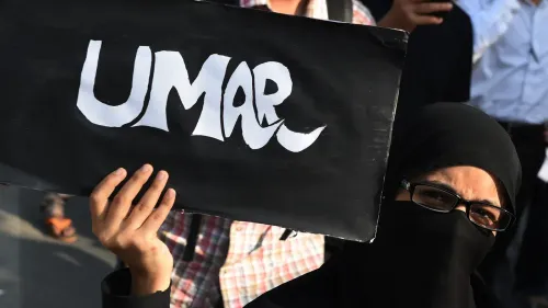 امرأة ترتدي حجابًا وتحمل لافتة مكتوب عليها "عمر" خلال احتجاج، تعبيرًا عن دعمها للناشط عمر خالد المسجون.