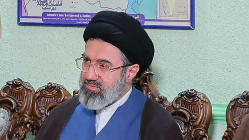 مجتبى خامنئي، المرشد الأعلى الجديد لإيران، يجلس في مقابلة، مع خلفية تضم خريطة، في وقت حساس تاريخيًا للبلاد بعد اغتيال والده.