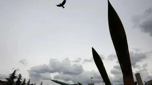 صورة تظهر صواريخ في قاعدة عسكرية إيرانية مع طائر يحلق في السماء، تعكس التوترات الحالية بين إيران والولايات المتحدة.