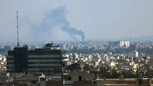 دخان يتصاعد من منطقة في طهران، مع منظر عام للمدينة، في سياق التوترات السياسية بين إيران والولايات المتحدة.