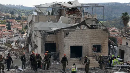 موقع الهجوم الصاروخي الإيراني في بيت شيمش، يظهر دمارًا كبيرًا في المبنى مع وجود فرق الإنقاذ في الموقع.