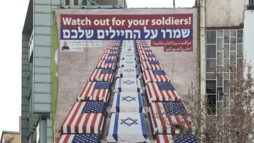لافتة تحذر الجنود الإسرائيليين، تظهر توابيت مغطاة بالأعلام الأمريكية والإسرائيلية، تعكس التوترات المتصاعدة في الشرق الأوسط.