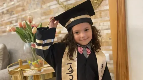 طفلة فلسطينية ترتدي زي التخرج بابتسامة، تمثل الطفلة هند رجب التي قُتلت في هجوم إسرائيلي وسط صراع غزة.