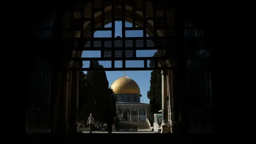 قبّة الصخرة في المسجد الأقصى تظهر من خلال بوابة مظللة، مع تزايد الإجراءات الإسرائيلية والتدريبات العسكرية في الموقع.